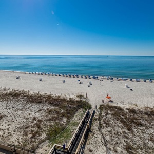 Take in the serene views of the calm water and beach from your spacious outdoor balcony, perfect for relaxation