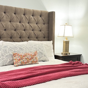 Sink into the plush king bed adorned with a colorful throw and decorative pillows in the master suite