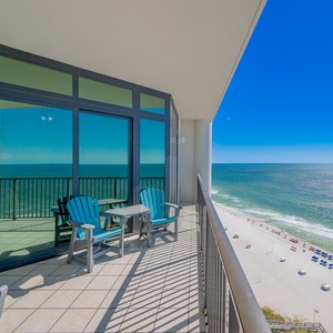 Relax on the balcony with turquoise chairs, enjoying views of the pristine beach and sparkling waters