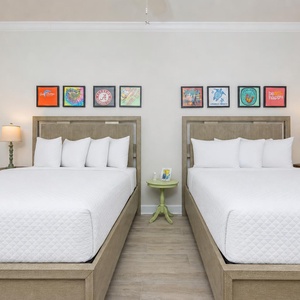Rest comfortably in this guest bedroom with two queen beds and vibrant artwork that adds a cheerful touch