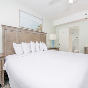 Inviting room featuring a plush king bed, stylish blue lamp, and access to an en-suite bathroom