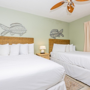 Sleep peacefully in this inviting guest room with two comfortable double beds, coastal decor, and soft lighting