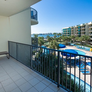 Lounge on the balcony overlooking the refreshing pool, lazy river, stunning bay water, and marina activity