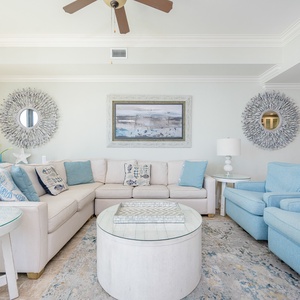 Bright and airy living room featuring cozy seating, coastal decor, and a stylish round coffee table for relaxation