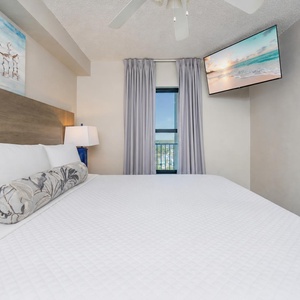 Fluffy pillows invite you to relax in the king suite for a calm movie night after a fun day at the beach