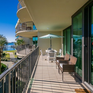 Relax on the spacious balcony, sipping drinks under the umbrella, with breezy views of the tranquil bay