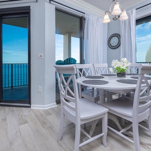 Dine at the round table with floral accents and enjoy views through sliding glass doors leading to the balcony