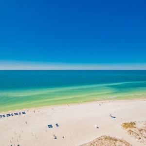 This beachfront balcony view showcases vibrant turquoise waters and soft white sand, perfect for relaxation and fun