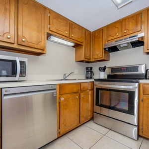 The kitchen features wood cabinetry, stainless appliances, and a convenient layout for preparing meals during your stay