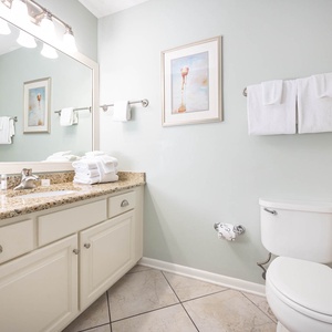 Enjoy the guest bathroom with a granite countertop, ample storage, and soft towels