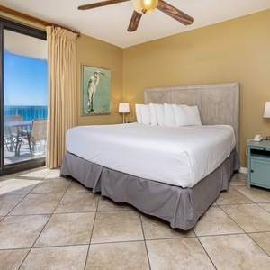 Relax in the master bedroom featuring a comfortable king bed, soft lighting, and beachfront balcony access