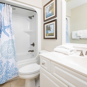 Refresh in this guest bath, featuring soft towels and soothing decor for your rejuvenating beach retreat