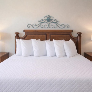The king suite features a beautifully crafted wooden bed with plush pillows and warm bedside lamps, perfect for restful nights