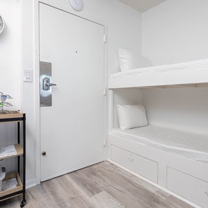 This cozy area features a bunk bed with fresh linens and a welcoming entryway, perfect for a restful stay