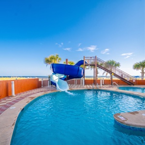Dive into fun at this beachfront pool area featuring a thrilling water slide and inviting blue waters for all ages
