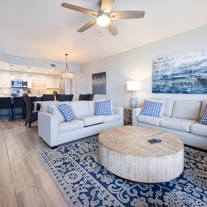 Relax in the inviting living area featuring a sofa with queen sleeper, a stylish coffee table, and a view into the kitchen