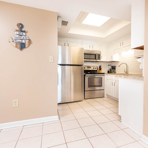 This kitchen features stainless appliances, granite countertops, and charming decor for a delightful cooking experience
