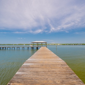 Experience serene waterfront views from the dock, perfect for fishing or relaxing by the water's edge in Gulf Shores