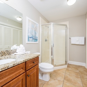 The extra bath features granite countertops, a glass walk-in shower, nautical décor, and laundry area with washer and dryer