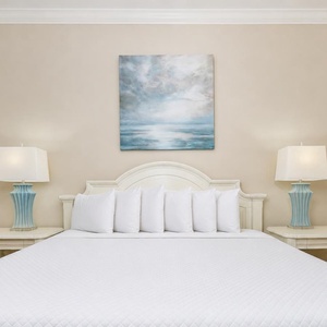 Experience restful nights in this serene guest room, surrounded by fluffy bedding and calming decor