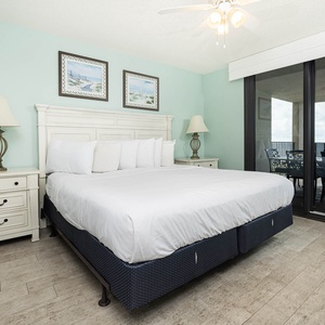 Relax in this serene master bedroom featuring a king bed, coastal decor, and beachfront balcony access
