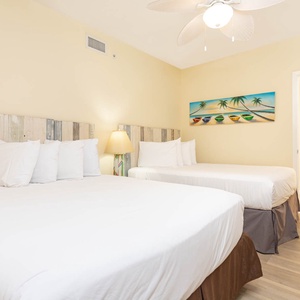 Sleep soundly in this inviting guest room with two queen beds, beach-themed decor, and a cheerful atmosphere
