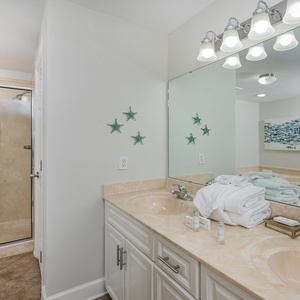 Refresh in the stylish master bathroom featuring a spacious walk-in shower, elegant fixtures, and beach décor