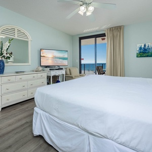 Unwind in the tranquil master bedroom featuring a king bed, a TV, and beachfront balcony access
