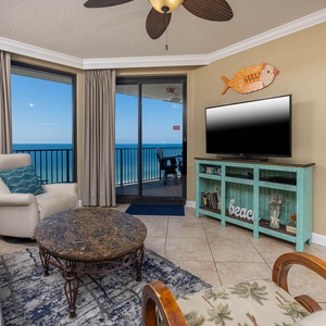 Unwind in the inviting living area with a large TV and stunning beach views through expansive windows