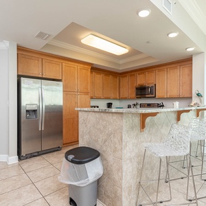 Prepare meals in the spacious kitchen, featuring stainless appliances and a breakfast bar for casual dining