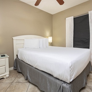 Rest comfortably in the serene guest bedroom with a queen bed, soft lighting, and elegant decor for a restful stay
