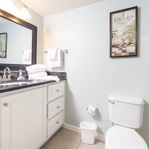 Stylish guest bathroom featuring a spacious vanity, elegant mirror, and fresh towels