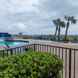 Relax by the pool surrounded by palm trees and lounge chairs, perfect for soaking up the sun and enjoying the view
