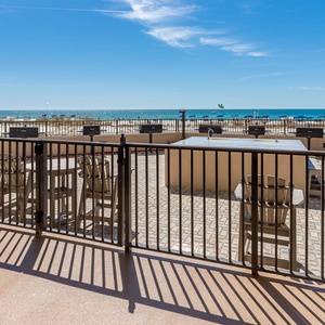 Step onto the outdoor area with seating and grills, perfect for enjoying the refreshing breeze and beach views