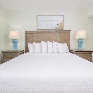 Serene king suite with fluffy pillows, plush bedding, and soft lighting, perfect for relaxation