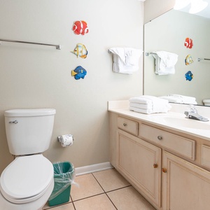 Brighten your day in this guest bathroom featuring colorful fish decor, fresh towels, and a spacious vanity