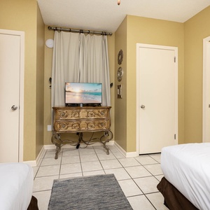 Relax in this inviting guest room featuring two double beds, a TV, and easy access to the bathroom with fresh towels