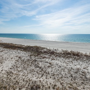 Gaze at the serene water and beach from your balcony, a perfect spot to unwind and enjoy the coastal ambiance
