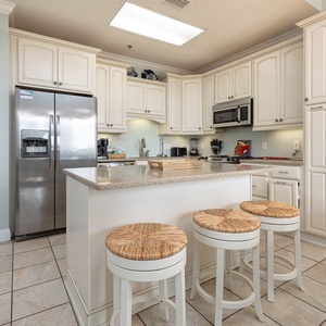 Kitchen features white cabinetry, a spacious island with seating, and modern appliances for a delightful cooking experience