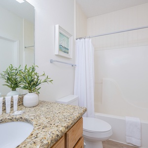 Refresh in this bathroom featuring a spacious granite countertop, soft towels, and a relaxing shower area