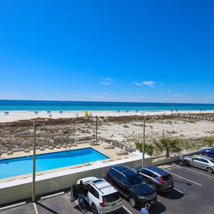 Enjoy stunning beachfront views from this inviting space, complete with a refreshing pool and lounge area below