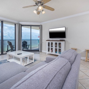 Relax on the comfortable sofa while enjoying views through large sliding glass doors that lead to the beachfront balcony