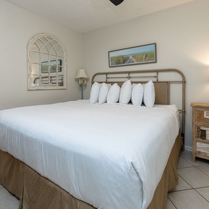 Cozy bedroom featuring a plush king bed, decorative pillows, and stylish wooden furniture for a relaxing retreat