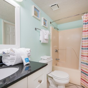 Refresh your spirit in this cheerful bathroom, enjoying plush towels and beach decor for a relaxing getaway