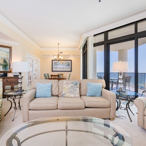 Comforting living area features cozy seating and a stunning view from expansive windows leading to a balcony