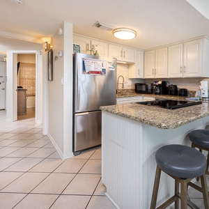 Open design with kitchen featuring stainless appliances, granite countertops, and cozy bar seating for a relaxing experience