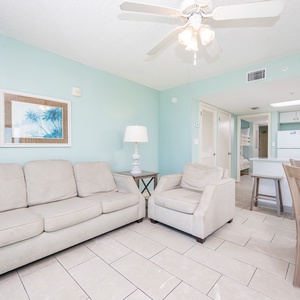 Relax in the inviting living area, featuring comfortable seating and a clear view into the kitchen space