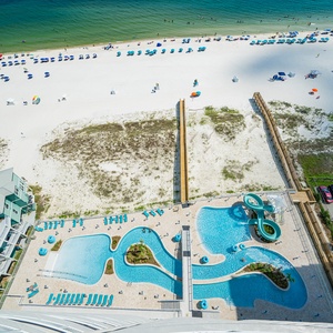 Vibrant pool area with a gradual entry, lazy river, and fun winding waterslide, perfect for sunbathing and relaxation
