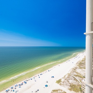 Expansive view of the beach and vibrant blue water from the balcony, perfect for relaxation and enjoyment