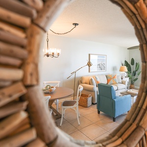 Gaze through a unique mirror frame to discover a cozy living area with inviting seating